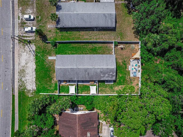 an aerial view of a house with a yard and outdoor seating