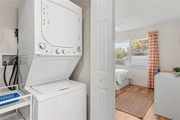 a view of washer and dryer with bathroom in the background