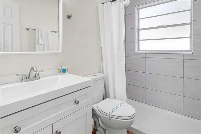 a bathroom with a sink toilet and window