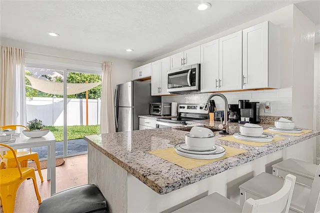 a kitchen with kitchen island granite countertop wooden cabinets and a counter top space