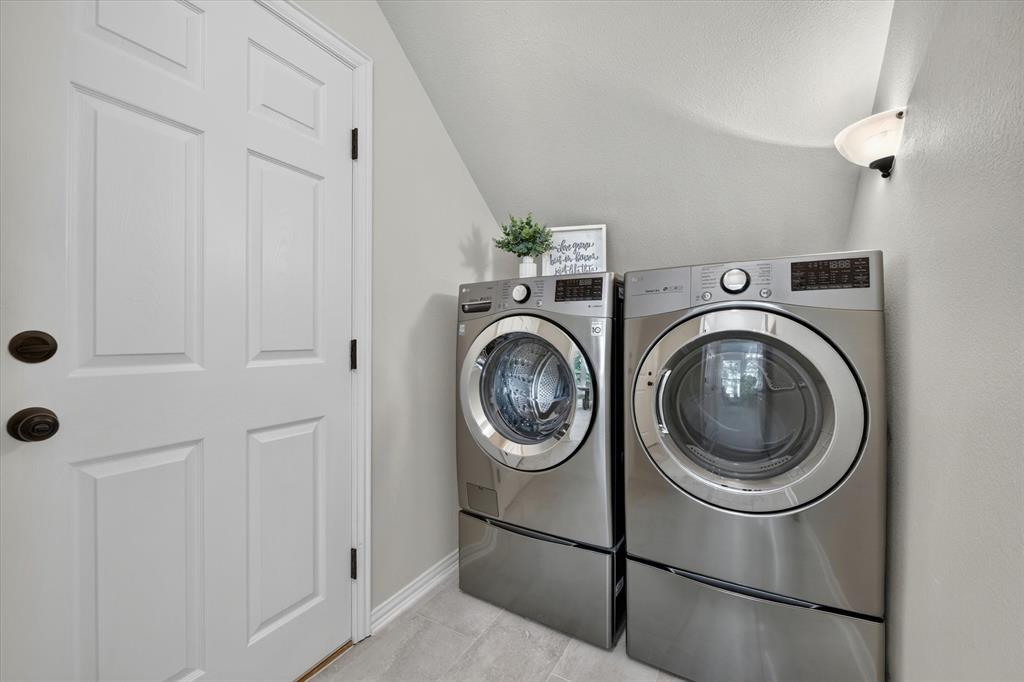 421 Ben Boyd Road Argyle, TX 76226 - Photo 17 of 25 Dedicated laundry area featuring light gray walls, a white paneled door with dark hardware, and light-toned tile flooring