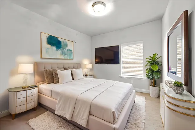 a bedroom with a bed and a flat screen tv