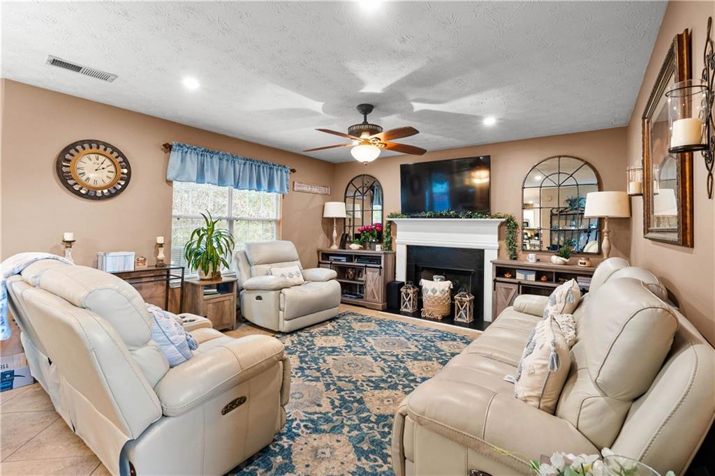 1380 Pebble Beach Lane Hampton, GA 30228 - Photo 11 of 59 a living room with furniture a fireplace and a flat screen tv