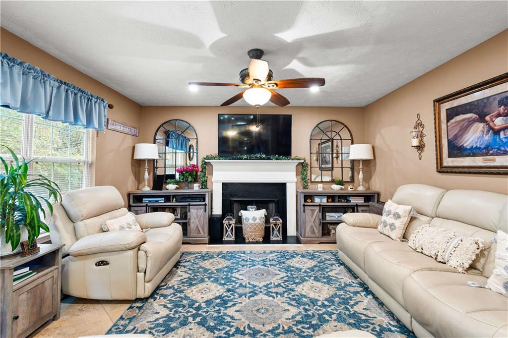 1380 Pebble Beach Lane Hampton, GA 30228 - Photo 12 of 59 a living room with furniture a fireplace and a flat screen tv