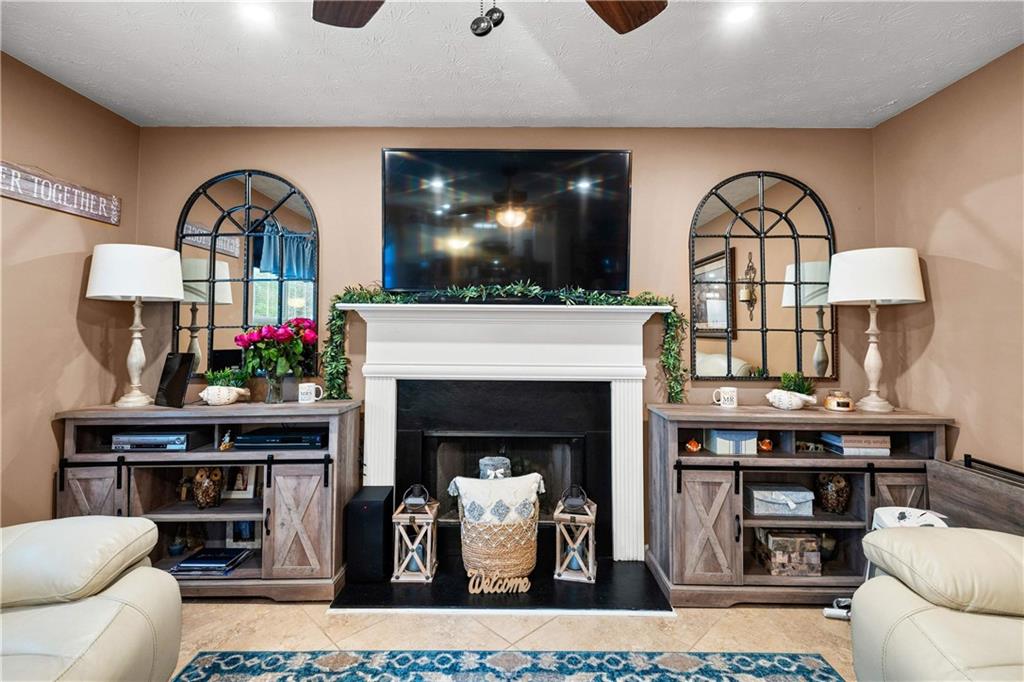 1380 Pebble Beach Lane Hampton, GA 30228 - Photo 13 of 59 a living room with furniture a flat screen tv and a fireplace