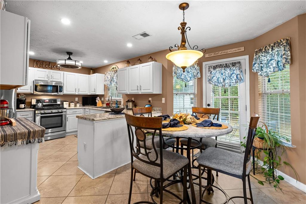 1380 Pebble Beach Lane Hampton, GA 30228 - Photo 16 of 59 a view of a dining room with furniture large windows and wooden floor
