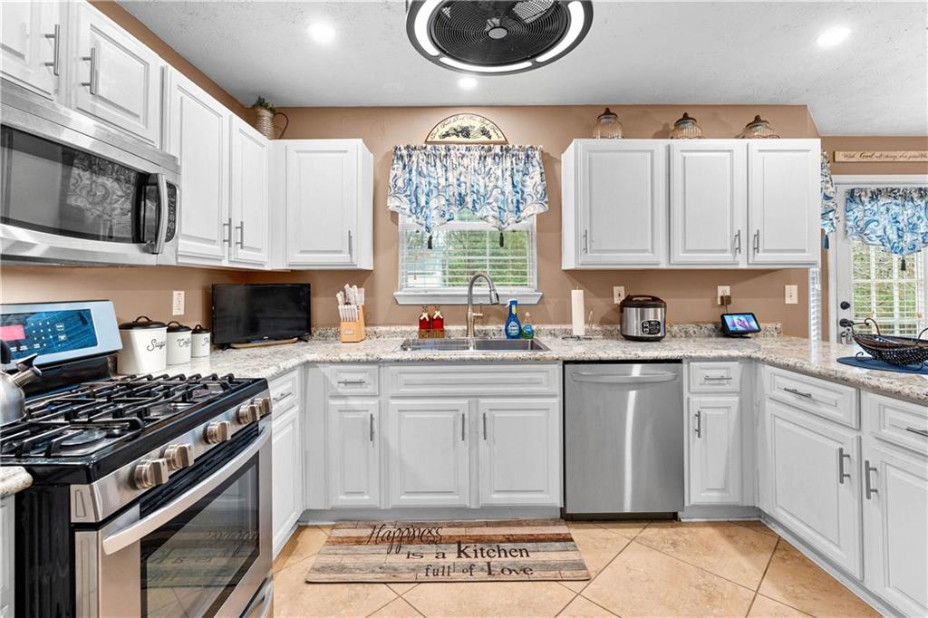 1380 Pebble Beach Lane Hampton, GA 30228 - Photo 19 of 59 a kitchen with cabinets appliances and a window
