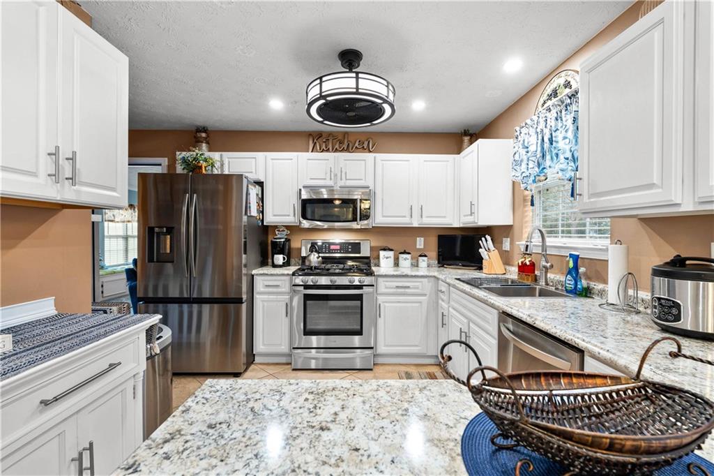 1380 Pebble Beach Lane Hampton, GA 30228 - Photo 20 of 59 a kitchen with stainless steel appliances granite countertop a stove refrigerator and cabinets