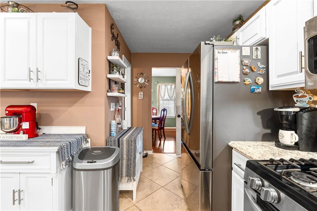 1380 Pebble Beach Lane Hampton, GA 30228 - Photo 21 of 59 a kitchen with stainless steel appliances granite countertop a stove and a refrigerator
