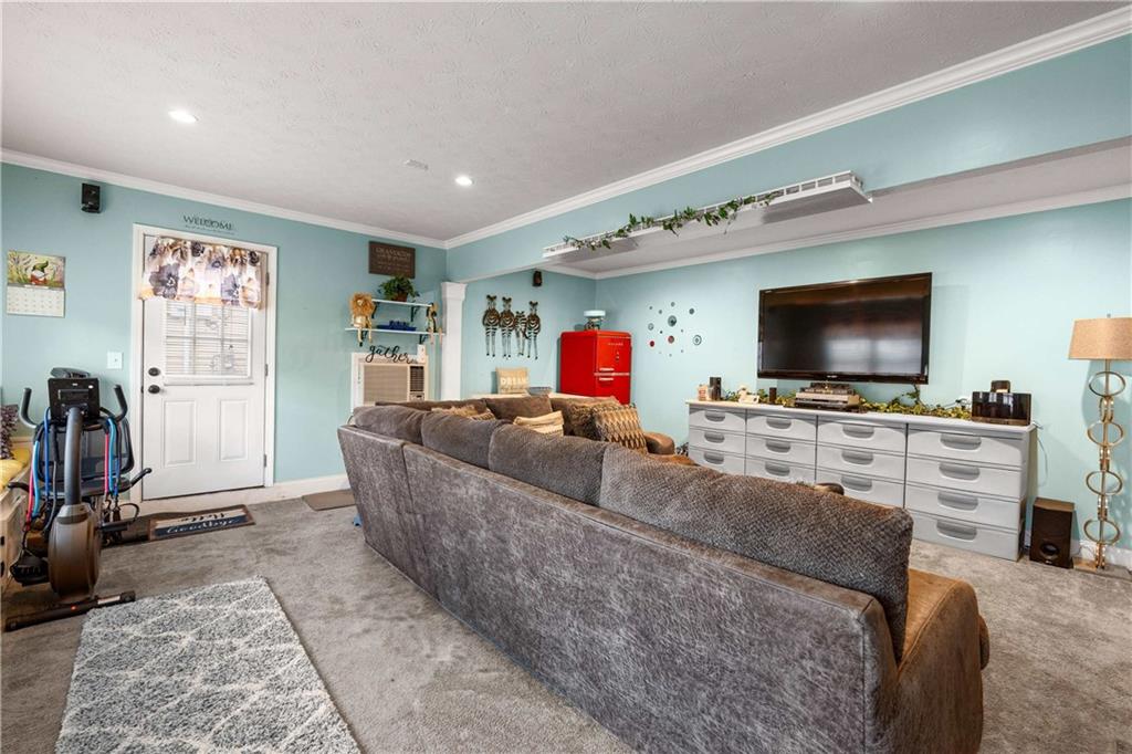 1380 Pebble Beach Lane Hampton, GA 30228 - Photo 26 of 59 a living room with furniture and a flat screen tv