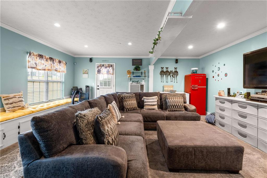 1380 Pebble Beach Lane Hampton, GA 30228 - Photo 27 of 59 a living room with furniture a flat screen tv and a large window