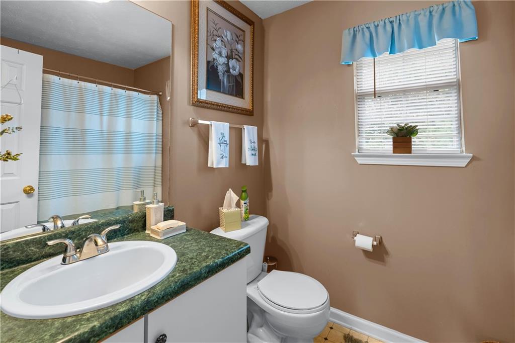 1380 Pebble Beach Lane Hampton, GA 30228 - Photo 42 of 59 a bathroom with a granite countertop sink a toilet and a mirror