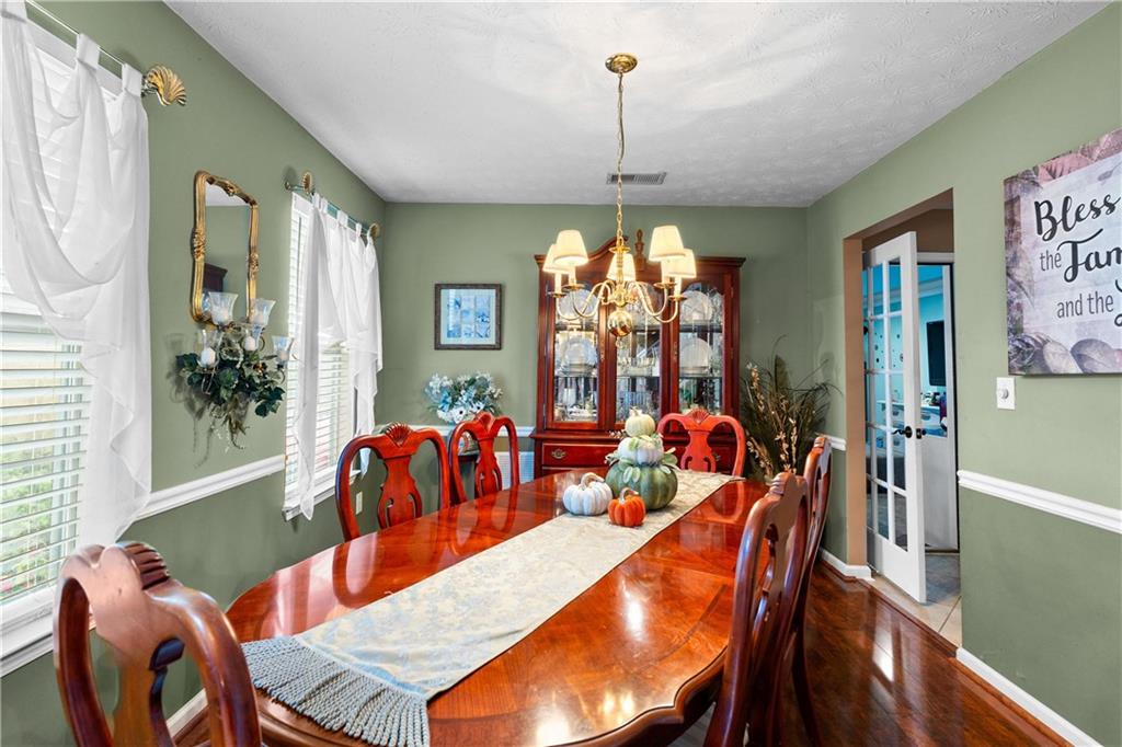 1380 Pebble Beach Lane Hampton, GA 30228 - Photo 9 of 59 a dining room with furniture a chandelier and window