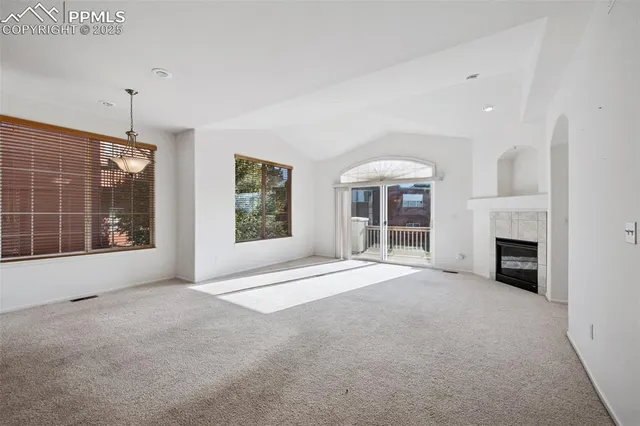 a view of an empty room with a fireplace and a window