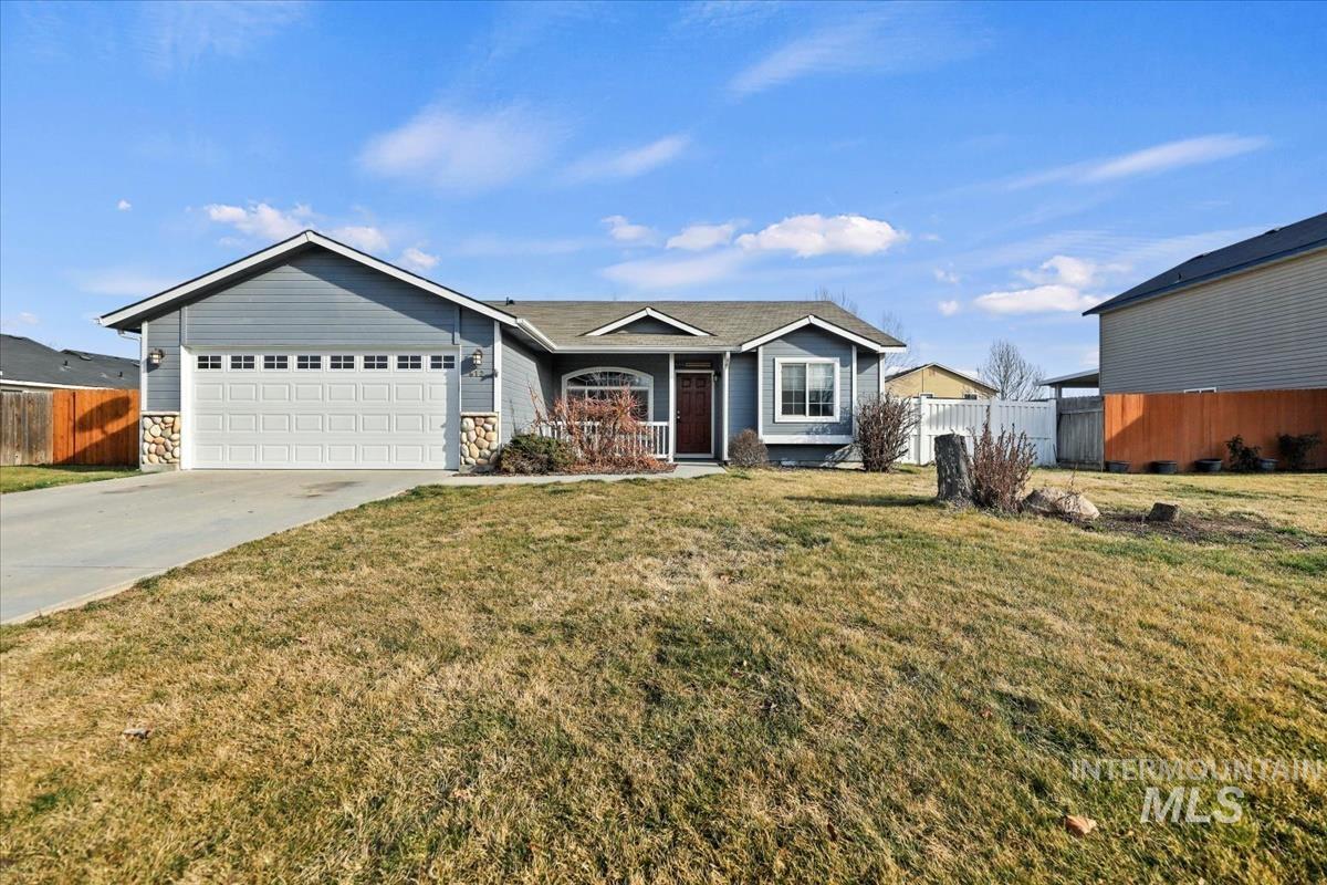 Single story home featuring driveway, a garage, stone siding, and covered porch