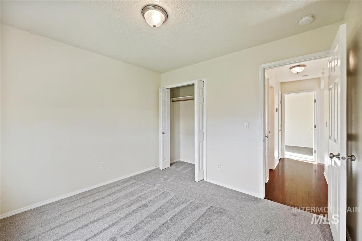 612 Goshawk Avenue Middleton, ID 83644 - Photo 25 of 36 Unfurnished bedroom featuring carpet flooring, a closet, and a textured ceiling
