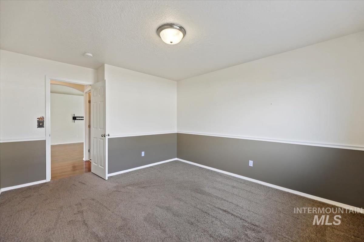 612 Goshawk Avenue Middleton, ID 83644 - Photo 27 of 36 Carpeted empty room with arched walkways and a textured ceiling