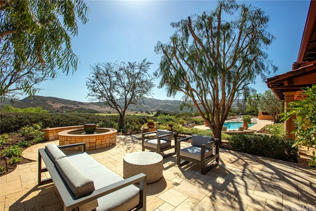 32 Boulder View Irvine, CA 92603 - Photo 20 of 73 a view of a patio with couches table and chairs under an umbrella with large trees