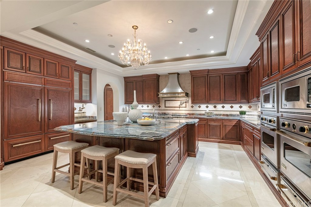 32 Boulder View Irvine, CA 92603 - Photo 62 of 73 a kitchen with stainless steel appliances kitchen island granite countertop a table chairs sink and cabinets