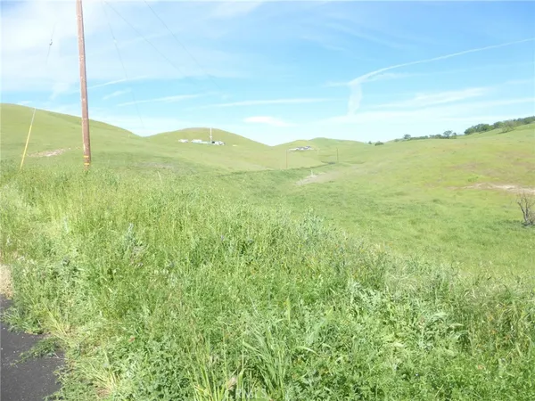 a view of a dry yard and mountain view