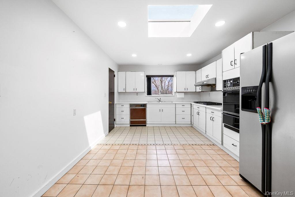 11 Valley View Road Great Neck, NY 11021 - Photo 7 of 19 a kitchen with stainless steel appliances a refrigerator sink and cabinets
