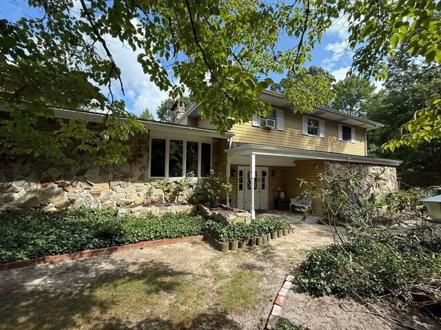 a front view of house with yard and trees around