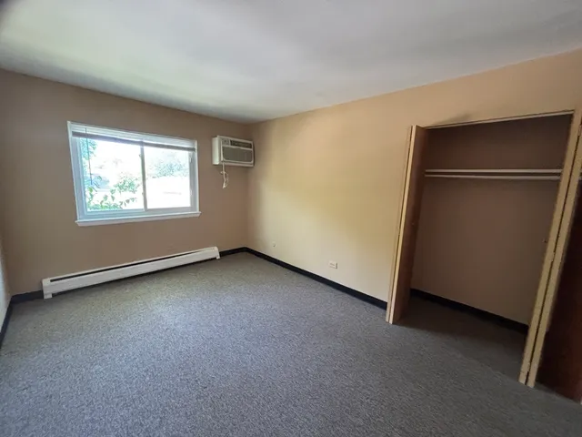 an empty room with windows and closet