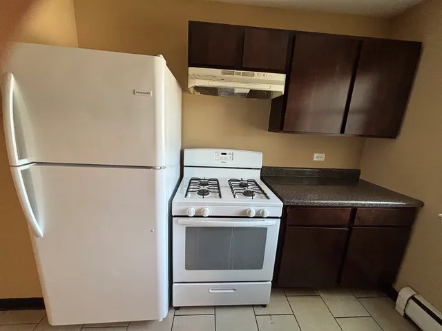 a white stove top oven sitting inside of a kitchen