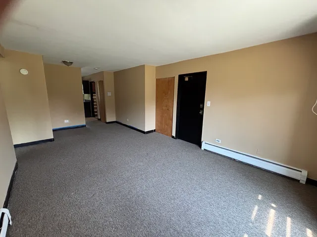a view of an empty room with closet and a window
