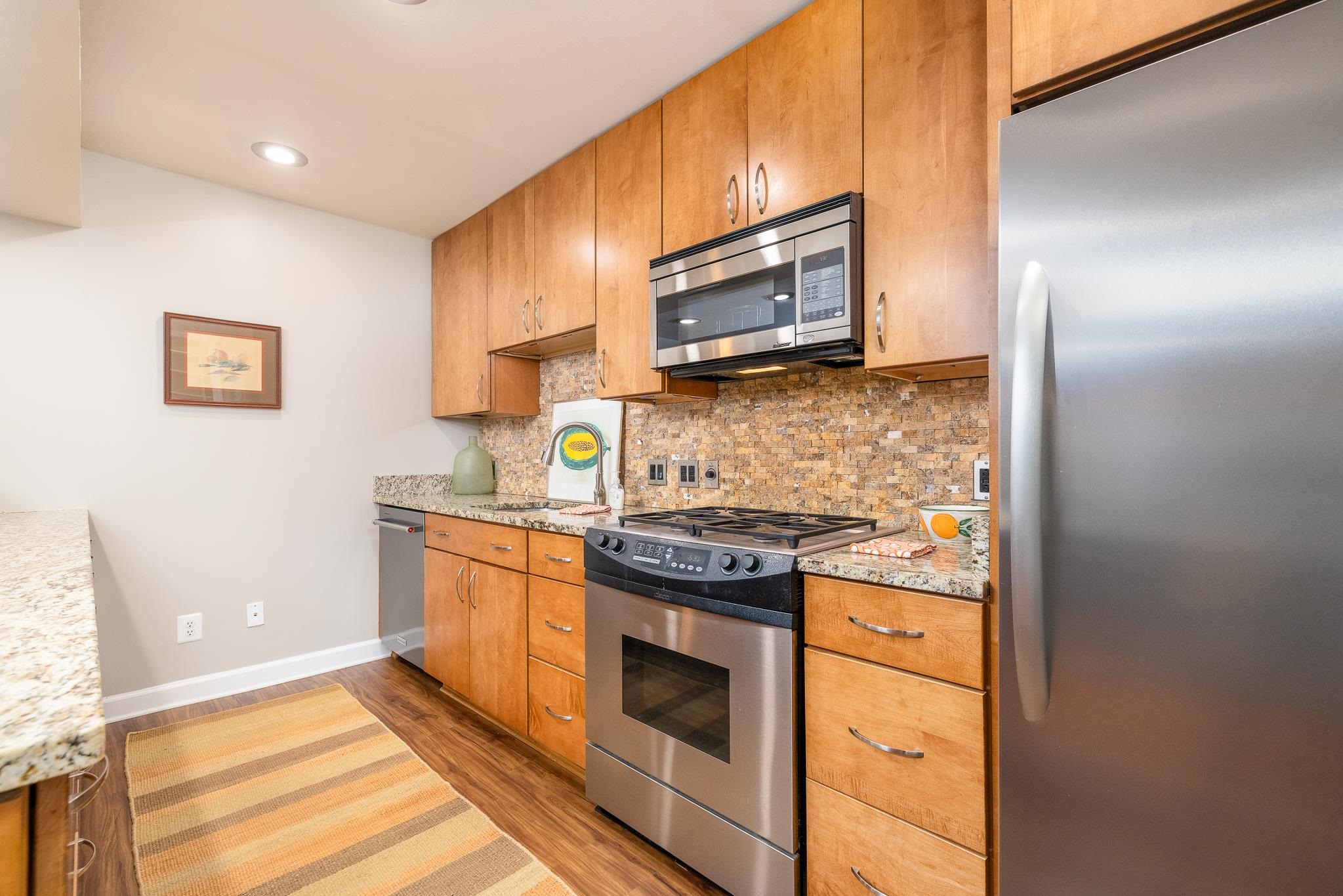 726 Hedgegrove Drive, Unit 3 Memphis, TN 38117 - Photo 7 of 30 a kitchen with stainless steel appliances a stove a microwave sink and cabinets