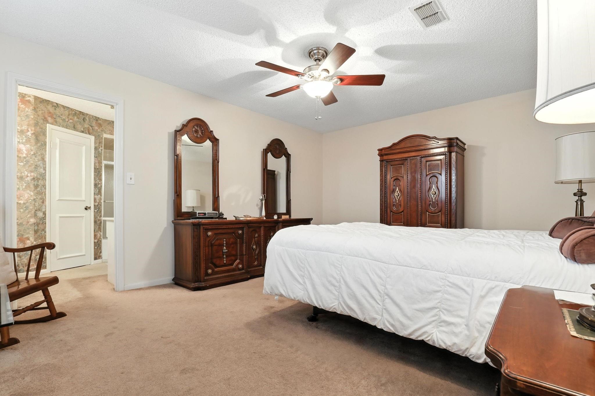 2910 Riata Lane Houston, TX 77080 - Photo 14 of 23 a bedroom with a bed and ceiling fan