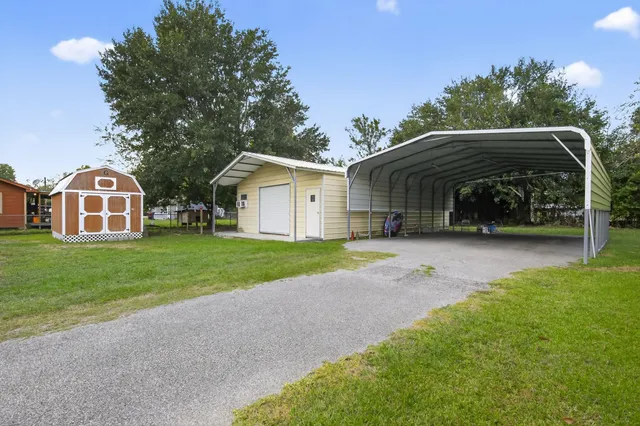 a view of house and yard with car parked