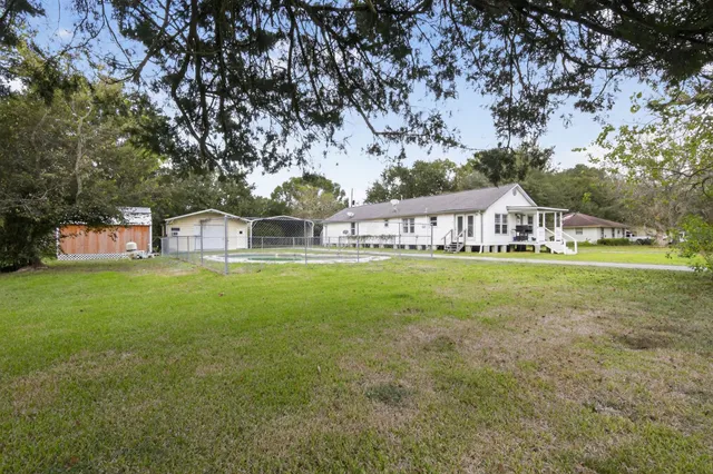 a view of house with garden space and sitting area
