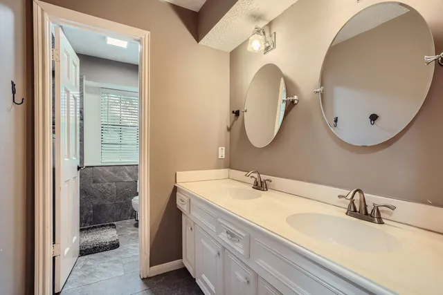 a bathroom with a double vanity sink and a mirror
