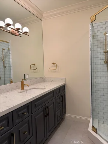 a bathroom with a granite countertop sink a mirror and a shower