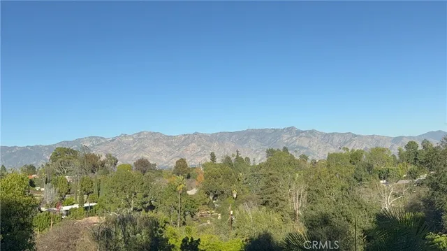 a view of a mountain range with lush green forest