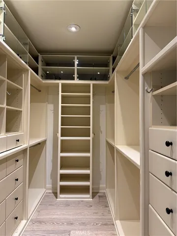 a view of walk in closet with empty racks