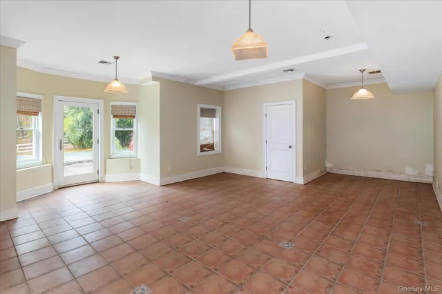 an empty room with windows and chandelier
