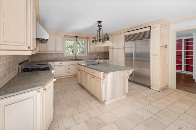 a kitchen with kitchen island granite countertop a sink counter top space cabinets and stainless steel appliances