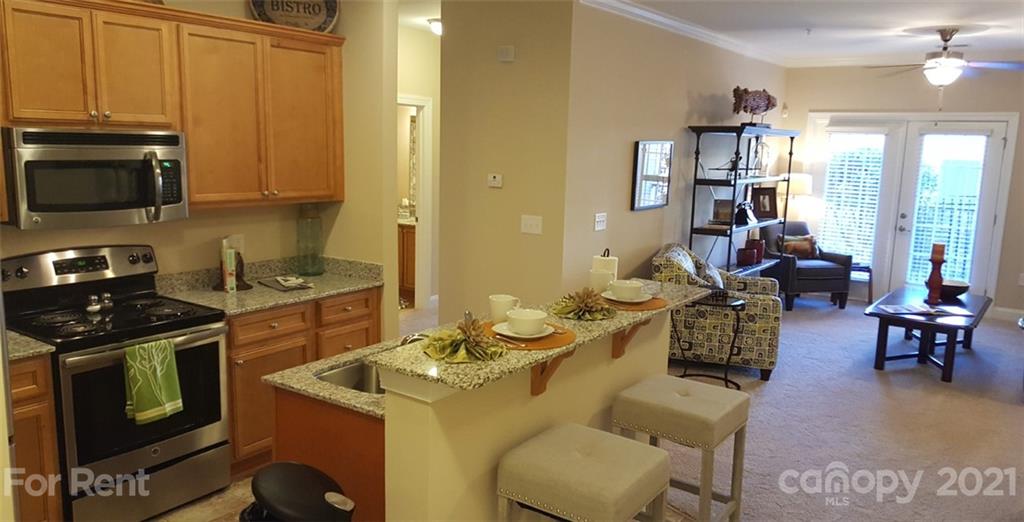 920 Stockbridge Drive Fort Mill, SC 29708 - Photo 17 of 20 a kitchen with stainless steel appliances granite countertop a stove a sink dishwasher a dining table and chairs with wooden floor