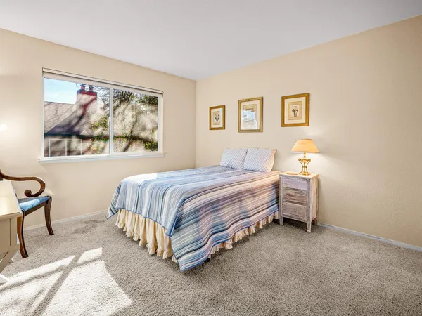 a spacious bedroom with a bed and a painting on the wall