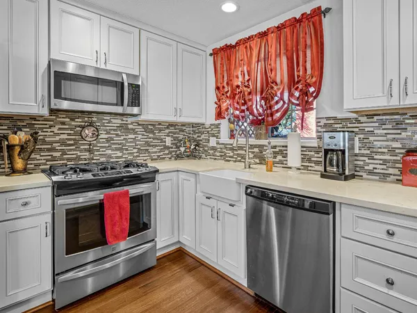 a kitchen with stainless steel appliances granite countertop a sink a stove a microwave and cabinets