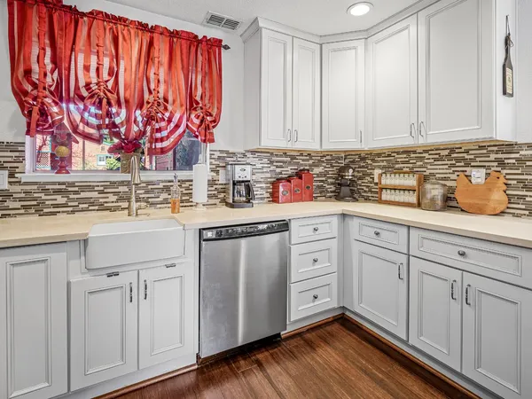 a kitchen with white cabinets and sink