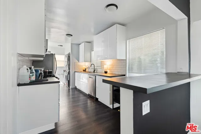 a kitchen with stainless steel appliances kitchen island a sink a stove and cabinets