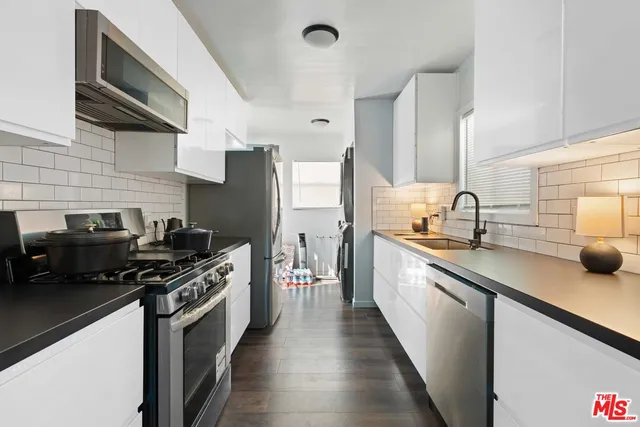 a kitchen with stainless steel appliances a sink dishwasher stove and refrigerator