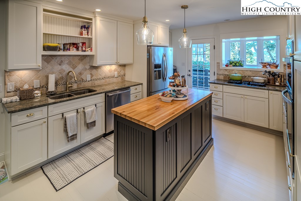 804 Crest Trail Linville, NC 28646 - Photo 14 of 40 a kitchen with granite countertop a sink a counter top space appliances and cabinets
