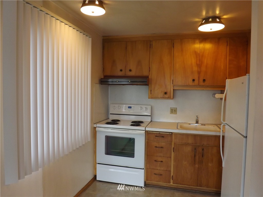 4215 Whitman Avenue North Seattle, WA 98103 - Photo 3 of 16 a kitchen with a stove sink and cabinets