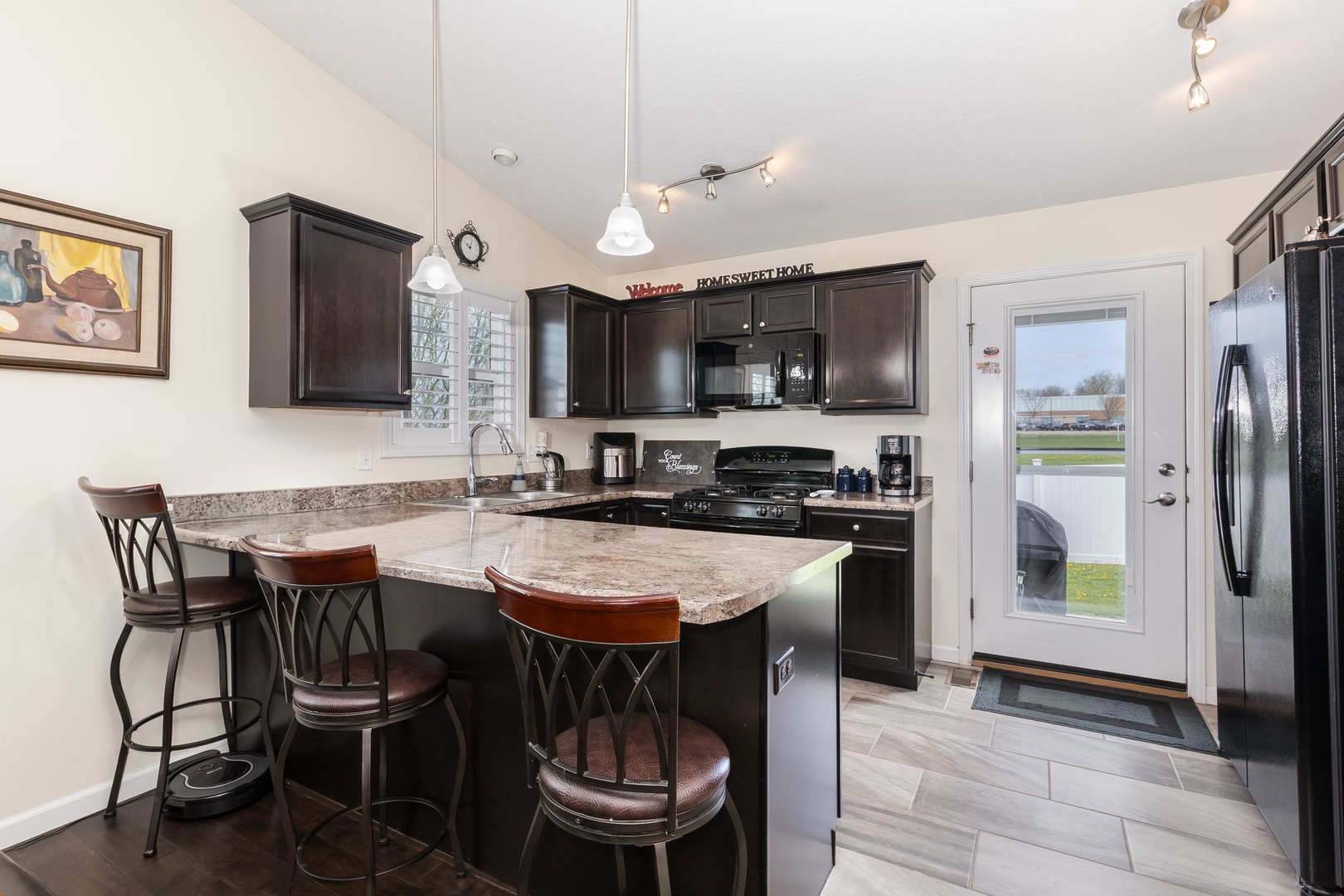 212 Springdale Avenue Bloomington, IL 61704 - Photo 11 of 37 a kitchen with a dining table chairs and refrigerator