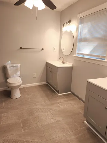 a bathroom with a toilet sink and mirror
