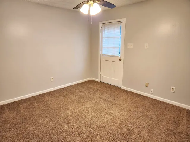 an empty room with a chandelier fan